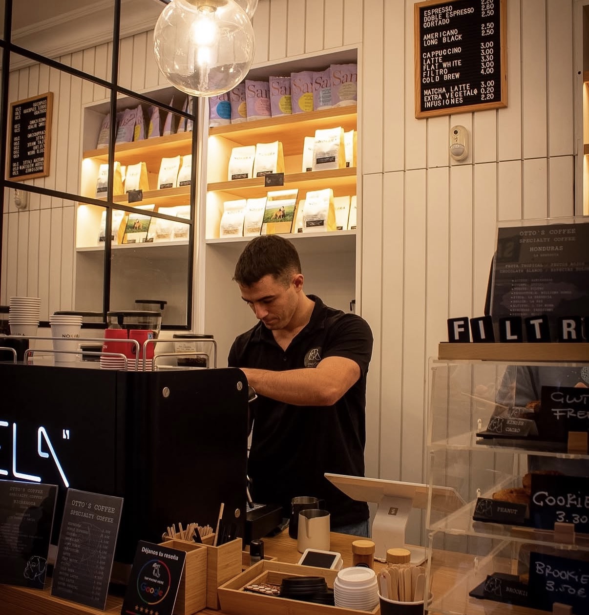 El barista preparando un café tras la máquina de espresso